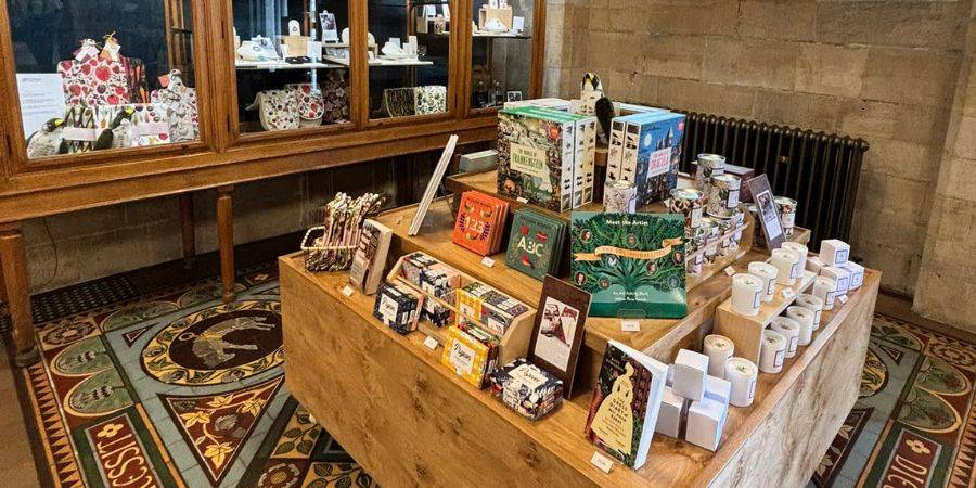 A wooden table filled with toys, books and gifts in an ornate room.