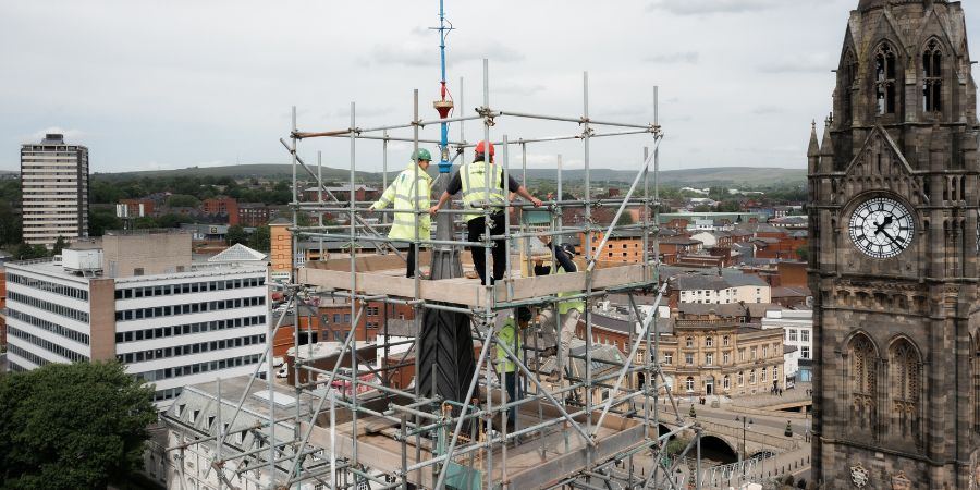 2 workers surveying the spire on top of Rochdale Town Hall.