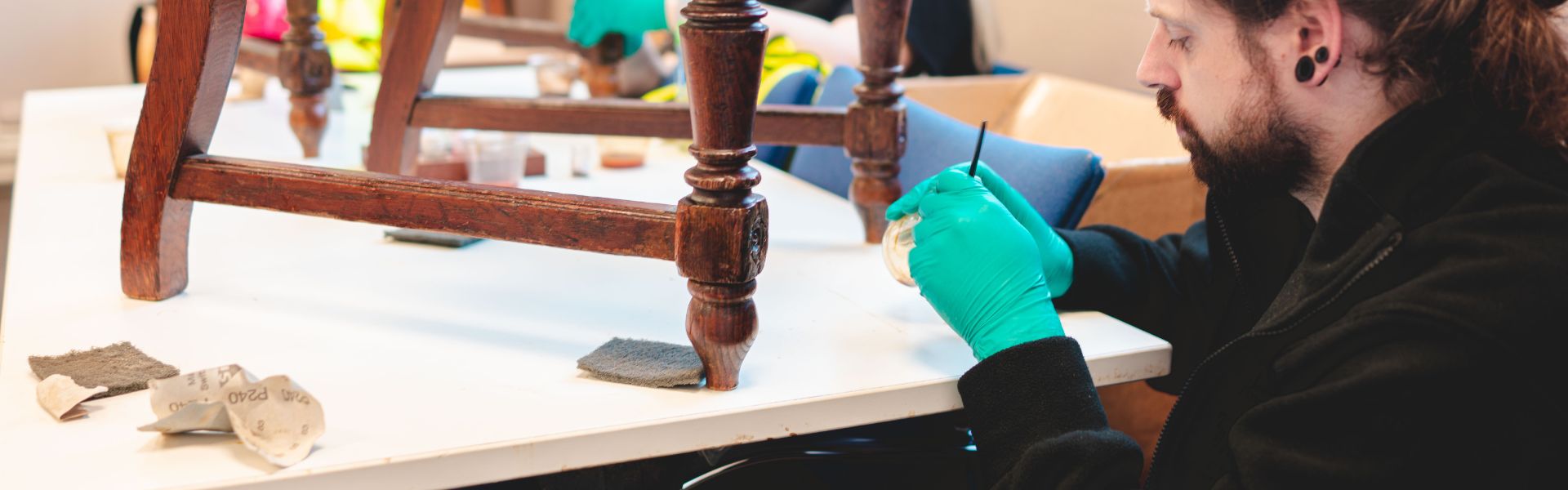 A volunteer restoring an old chair.